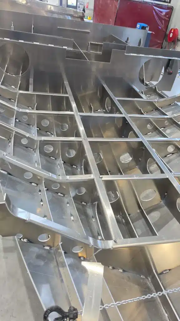 Spanten en langsverbanden uit een snijpakket voor een aluminium visboot, van bovenaf gezien
